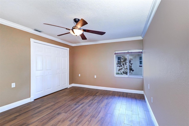 5449 Manatee Point Dr, New Port Richey, FL 34652 - unfurnished bedroom with dark wood-style floors, a closet, crown molding, a textured ceiling, and a ceiling fan