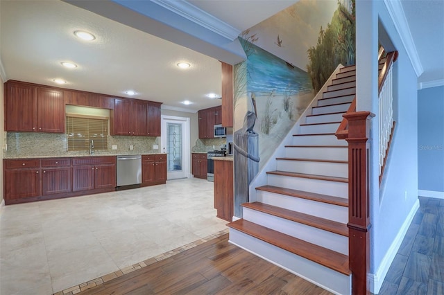 5449 Manatee Point Dr, New Port Richey, FL 34652 - kitchen with crown molding, appliances with stainless steel finishes, backsplash, recessed lighting, and light wood-style flooring