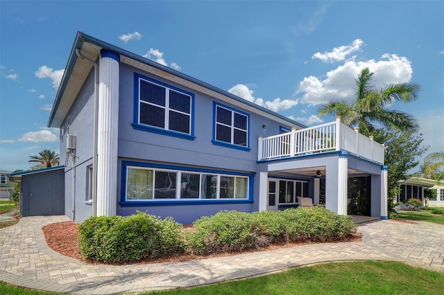5449 Manatee Point Dr, New Port Richey, FL 34652 - back of house featuring a balcony, stucco siding, and ceiling fan