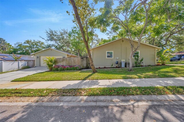 1155 Withlacoochee St, Safety Harbor, FL 34695 - view of front of home with concrete driveway, central AC unit, a front lawn, and fence