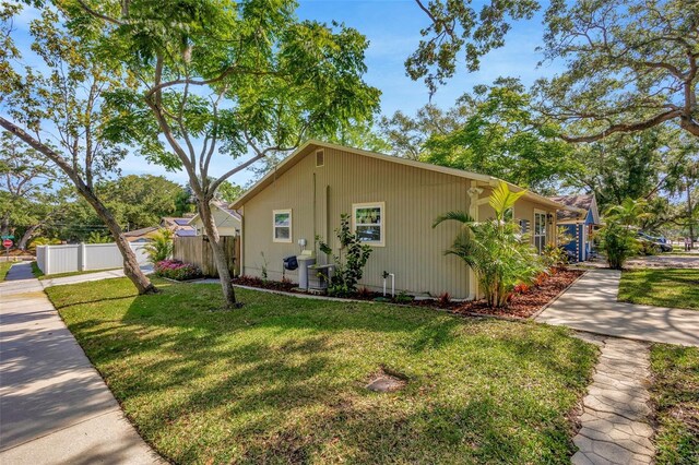1155 Withlacoochee St, Safety Harbor, FL 34695 - view of side of home with fence and a lawn