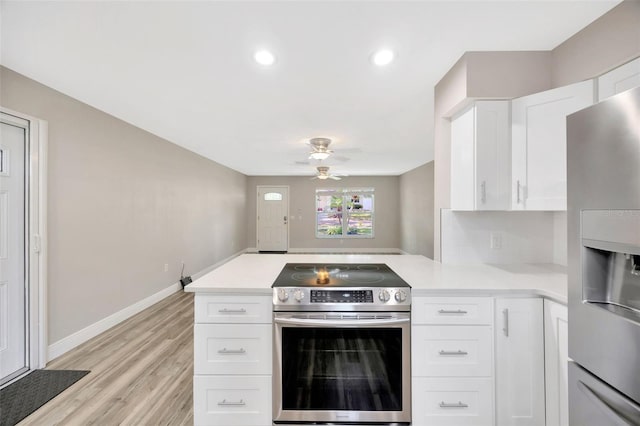 1155 Withlacoochee St, Safety Harbor, FL 34695 - kitchen featuring light wood-style flooring, appliances with stainless steel finishes, light countertops, a peninsula, and a ceiling fan