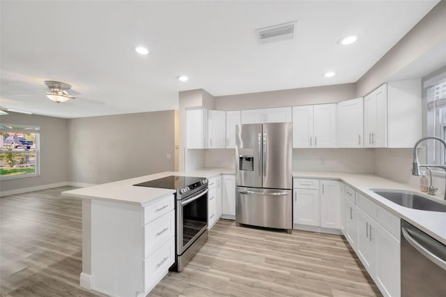 1155 Withlacoochee St, Safety Harbor, FL 34695 - kitchen with light countertops, visible vents, a sink, a peninsula, and appliances with stainless steel finishes