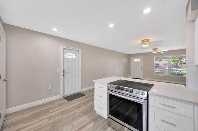 1155 Withlacoochee St, Safety Harbor, FL 34695 - kitchen featuring white cabinets, light wood-style floors, stainless steel electric range oven, and light countertops