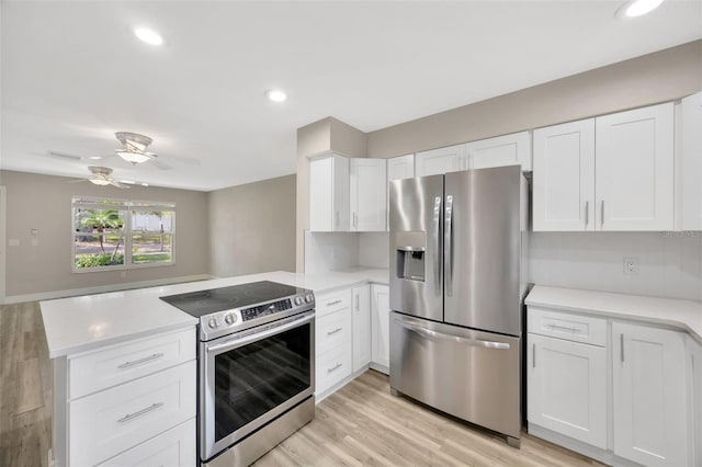 1155 Withlacoochee St, Safety Harbor, FL 34695 - kitchen with white cabinetry, a peninsula, stainless steel appliances, and light countertops