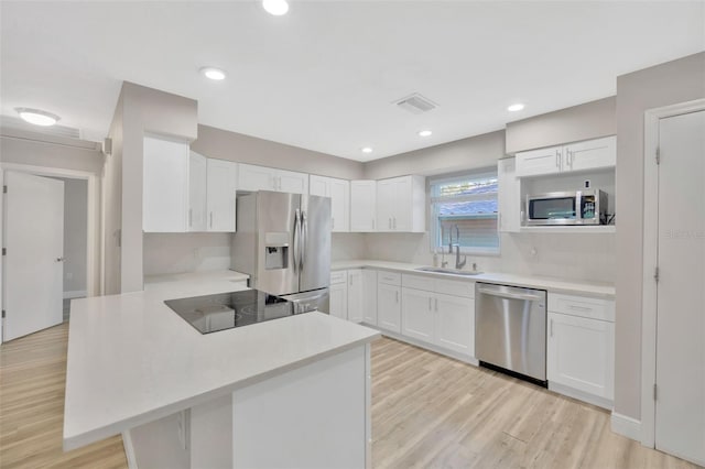 1155 Withlacoochee St, Safety Harbor, FL 34695 - kitchen featuring a peninsula, a sink, visible vents, light countertops, and appliances with stainless steel finishes