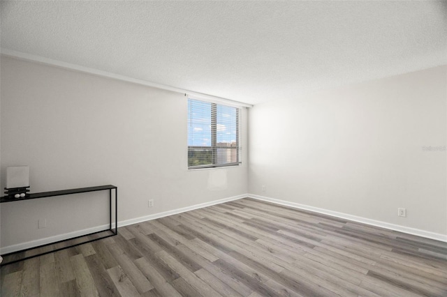 2616 Cove Cay Dr Unit 803, Clearwater, FL 33760 - empty room with wood finished floors, baseboards, and a textured ceiling