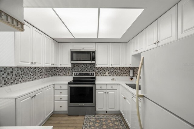 2616 Cove Cay Dr Unit 803, Clearwater, FL 33760 - kitchen with stainless steel appliances, white cabinetry, and tasteful backsplash