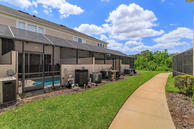 view of yard featuring cooling unit and glass enclosure