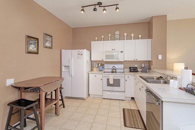 kitchen with a sink, light tile patterned flooring, white appliances, white cabinetry, and light countertops