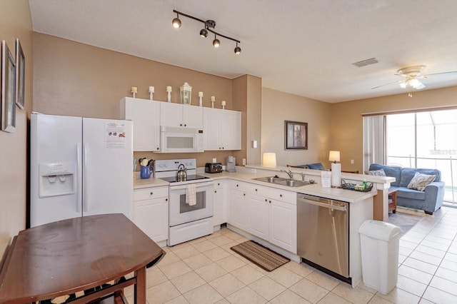 kitchen featuring a sink, visible vents, open floor plan, white appliances, and a peninsula