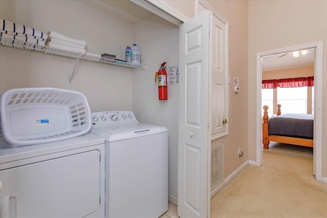 washroom with light colored carpet, visible vents, baseboards, washer and dryer, and laundry area