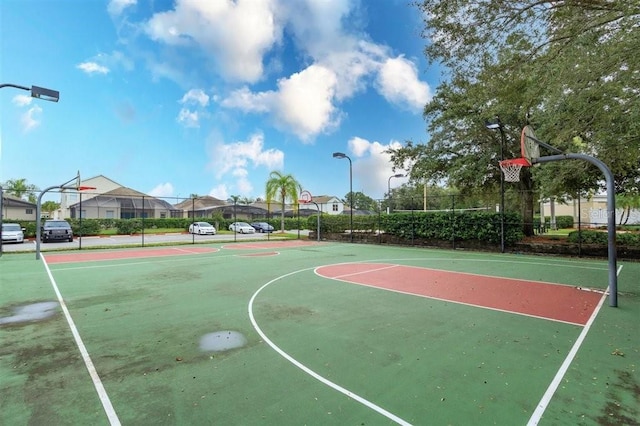 view of basketball court featuring fence, community basketball court, and a residential view