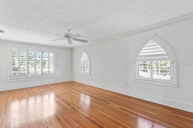 empty room featuring ceiling fan, plenty of natural light, baseboards, and hardwood / wood-style flooring