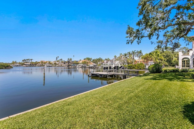 dock area with a lawn and a water view