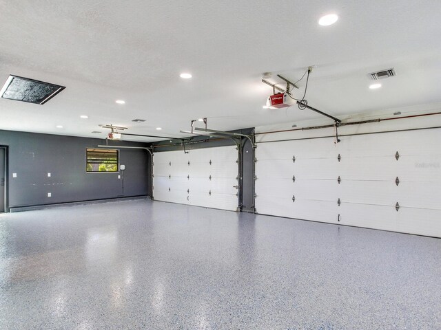 6310 95th St E, Bradenton, FL 34202 - garage featuring recessed lighting, visible vents, and a garage door opener
