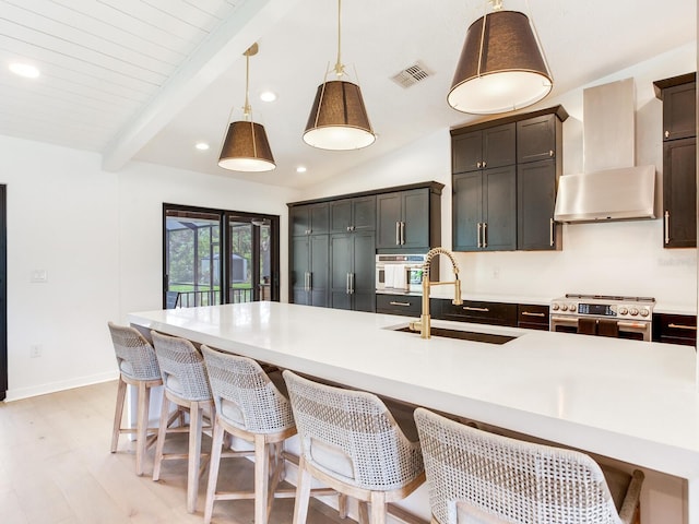 6310 95th St E, Bradenton, FL 34202 - kitchen with exhaust hood, a sink, a kitchen bar, visible vents, and high end stainless steel range oven