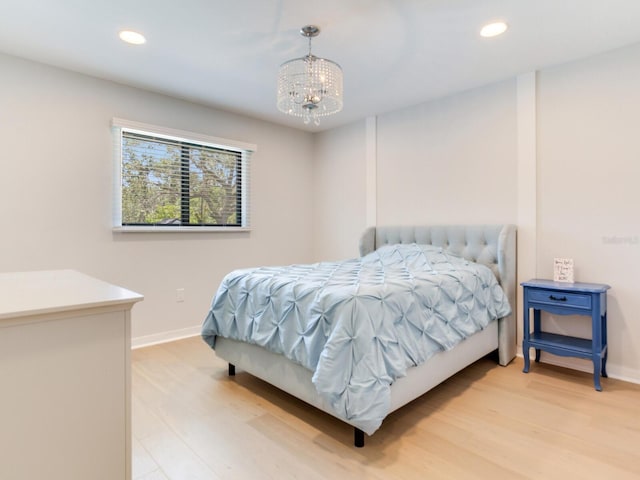 6310 95th St E, Bradenton, FL 34202 - bedroom featuring baseboards, light wood finished floors, and a chandelier
