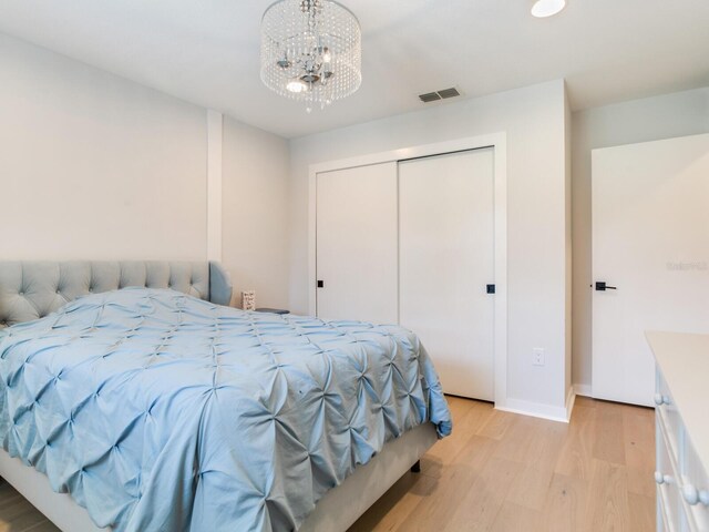 6310 95th St E, Bradenton, FL 34202 - bedroom featuring visible vents, a closet, an inviting chandelier, light wood-style floors, and baseboards