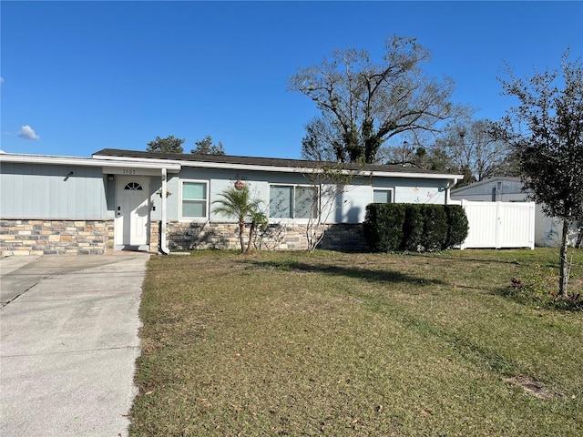 7503 N Howard Ave, Tampa, FL 33604 - view of front of home featuring fence, a front yard, and stone siding