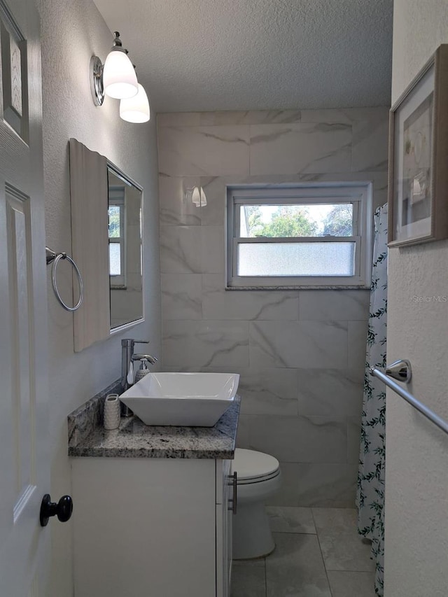 7503 N Howard Ave, Tampa, FL 33604 - full bath with vanity, toilet, a textured ceiling, and marble finish floor