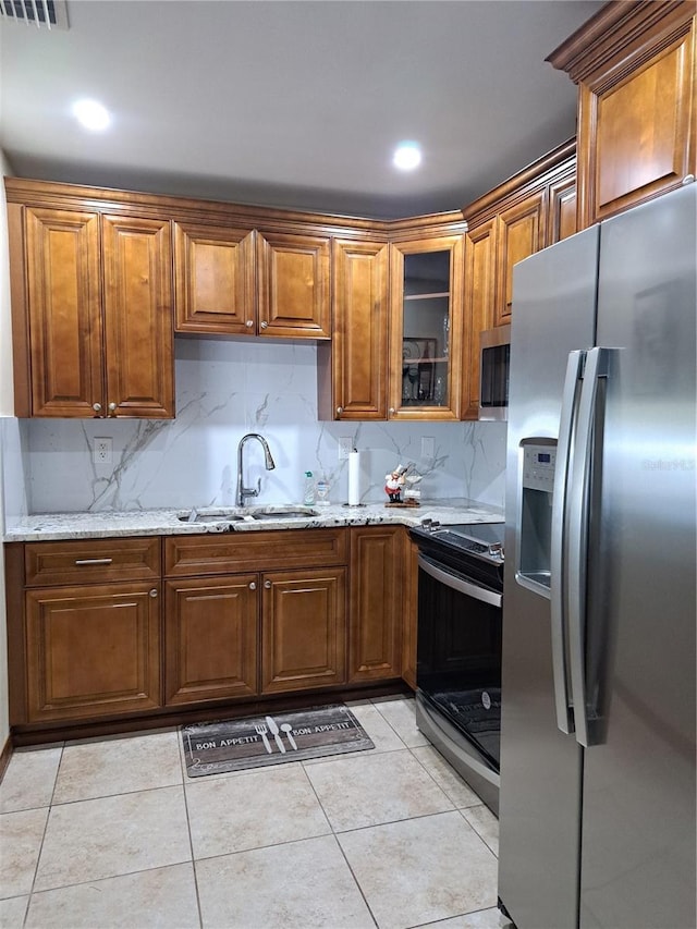 7503 N Howard Ave, Tampa, FL 33604 - kitchen with a sink, appliances with stainless steel finishes, light stone countertops, and brown cabinetry