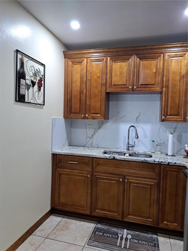 7503 N Howard Ave, Tampa, FL 33604 - kitchen featuring light tile patterned floors, light stone counters, a sink, and tasteful backsplash