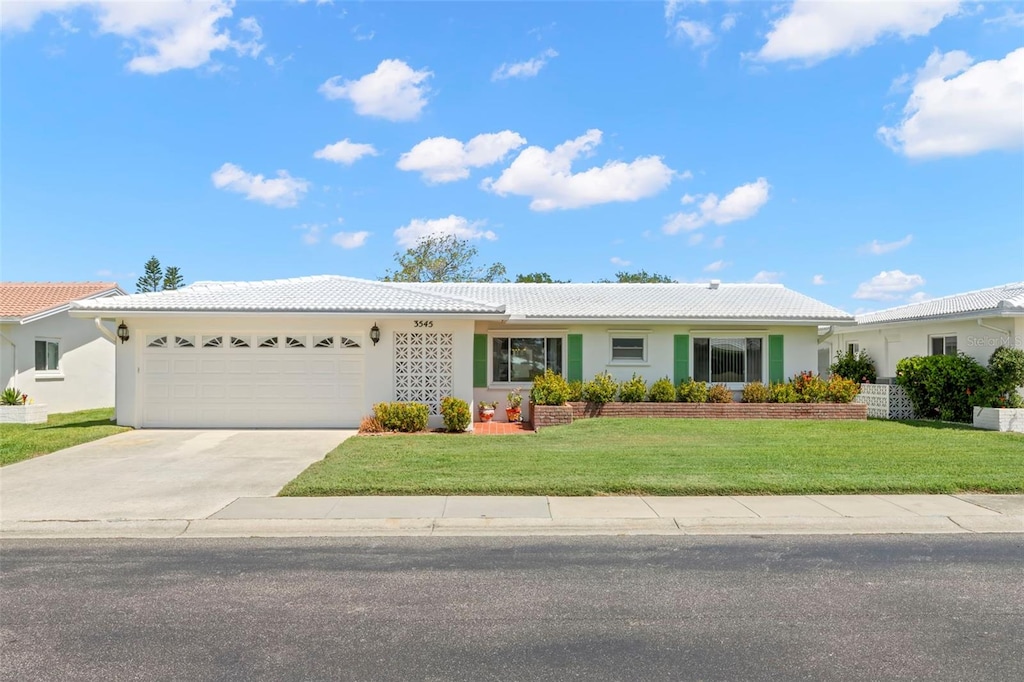 3545 97th Ave N Unit 4, Pinellas Park, FL 33782 - single story home featuring stucco siding, driveway, a tiled roof, and a garage