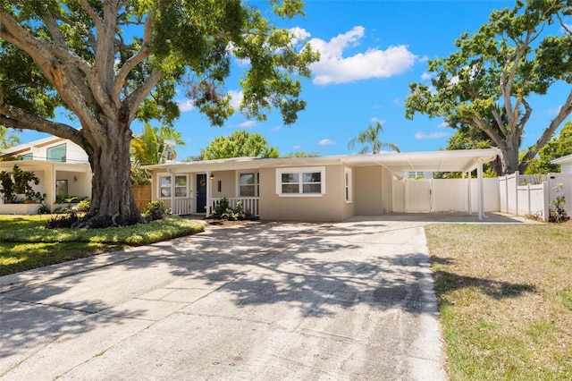 4519 S Grady Ave, Tampa, FL 33611 - ranch-style home featuring concrete driveway, stucco siding, and a carport