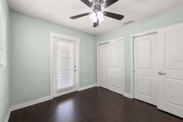 4519 S Grady Ave, Tampa, FL 33611 - unfurnished bedroom featuring baseboards, dark wood-style floors, two closets, and ceiling fan