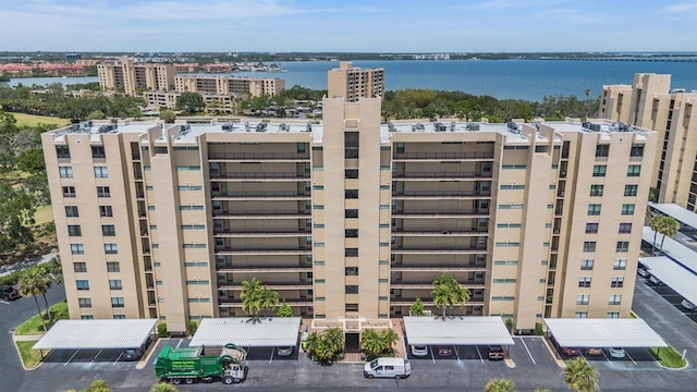 view of building exterior featuring uncovered parking and a water view
