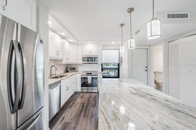kitchen with white cabinetry, stainless steel appliances, visible vents, and a sink