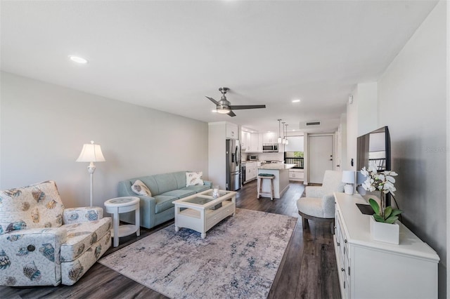 living room featuring dark wood finished floors, a ceiling fan, and recessed lighting