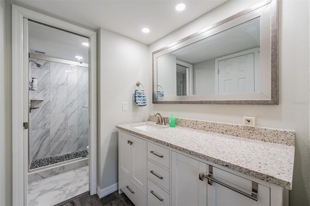 full bathroom with recessed lighting, wood finished floors, vanity, baseboards, and a stall shower