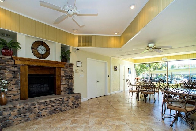 living room featuring baseboards, visible vents, a fireplace, and ceiling fan