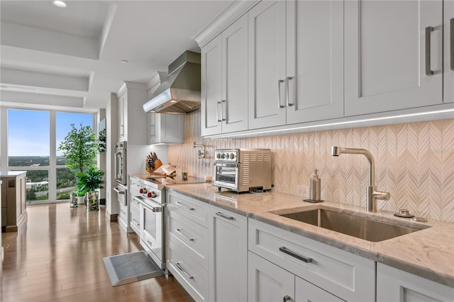 3301 Bayshore Blvd Unit 2401E, Tampa, FL 33629 - kitchen featuring a toaster, wall chimney exhaust hood, white cabinetry, a sink, and appliances with stainless steel finishes