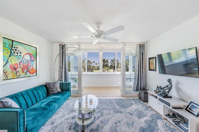 living area with wood finished floors, a textured ceiling, and ceiling fan