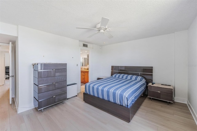 bedroom with a textured ceiling, ceiling fan, light wood-style flooring, baseboards, and visible vents