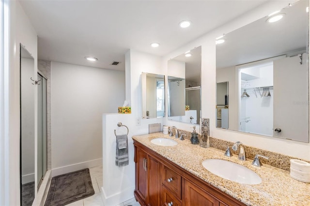 bathroom featuring double vanity, visible vents, a stall shower, and a sink