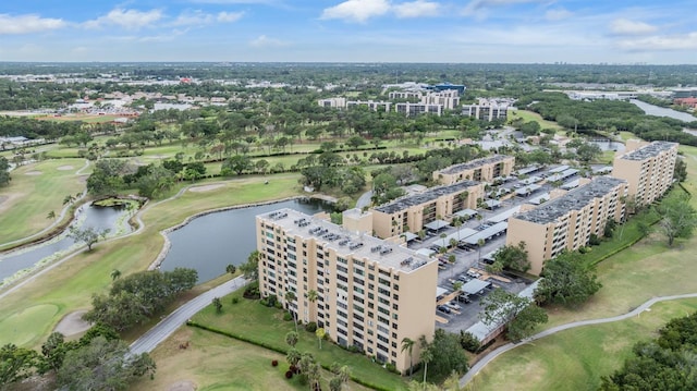 birds eye view of property with golf course view and a water view