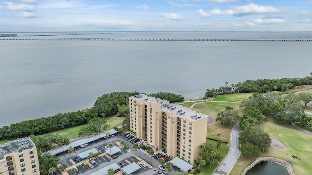 aerial view with golf course view and a water view