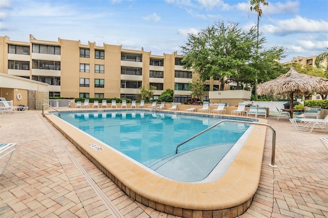 community pool with a patio area and fence