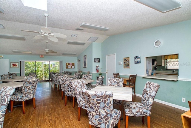 dining room featuring lofted ceiling, wood finished floors, a textured ceiling, and visible vents