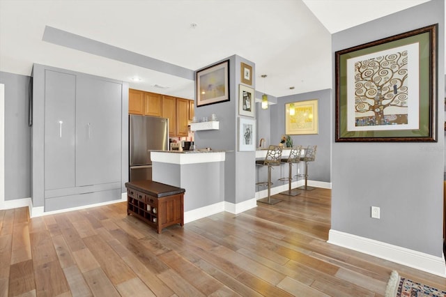 1238 E Kennedy Blvd Unit 702, Tampa, FL 33602 - kitchen featuring freestanding refrigerator, light wood-style flooring, baseboards, brown cabinetry, and recessed lighting