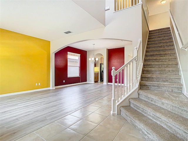 1705 Plantation Pointe Dr, Orlando, FL 32824 - entryway featuring arched walkways, a chandelier, tile patterned flooring, and stairway