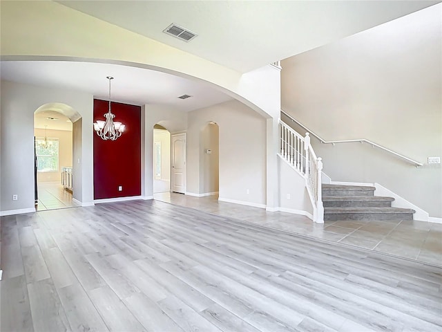 1705 Plantation Pointe Dr, Orlando, FL 32824 - unfurnished living room featuring wood finished floors, a chandelier, and stairs
