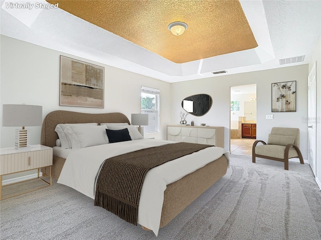 1705 Plantation Pointe Dr, Orlando, FL 32824 - bedroom with a raised ceiling, light carpet, ensuite bath, and a textured ceiling