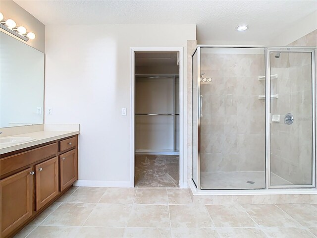 1705 Plantation Pointe Dr, Orlando, FL 32824 - full bath featuring vanity, a shower stall, tile patterned floors, a textured ceiling, and a walk in closet