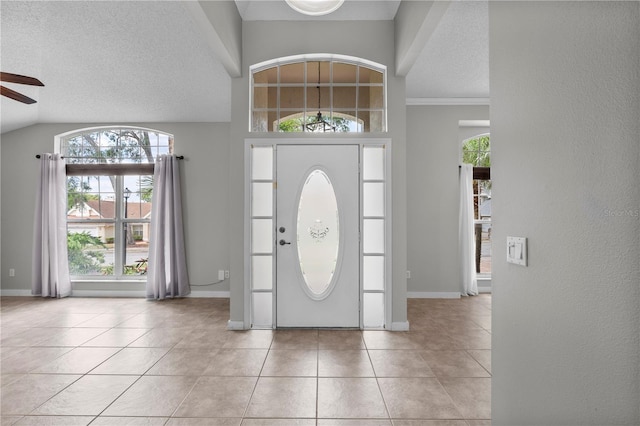 entrance foyer with baseboards, light tile patterned flooring, a textured ceiling, and ceiling fan