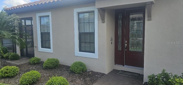 doorway to property featuring stucco siding
